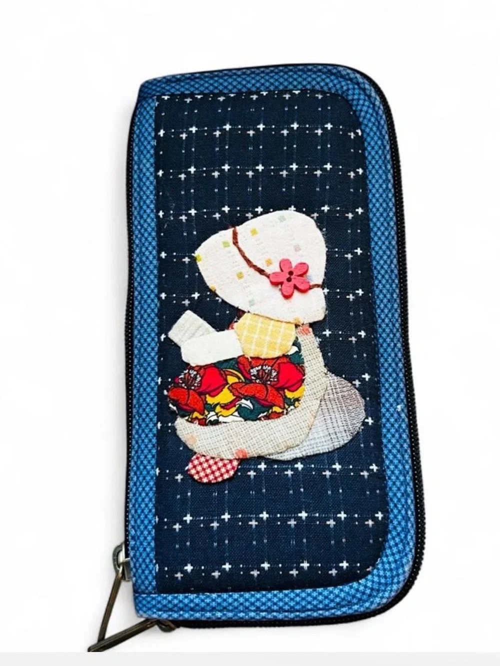 Handmade fabric patchwork wallet with appliquéd girl in a hat and flowers